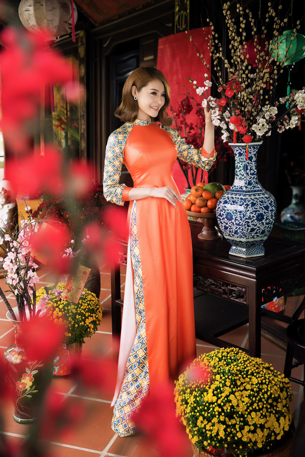 Linh Chi điệu đà với trang phục truyền thống, tạo dáng trong không gian đầy sắc xuân.