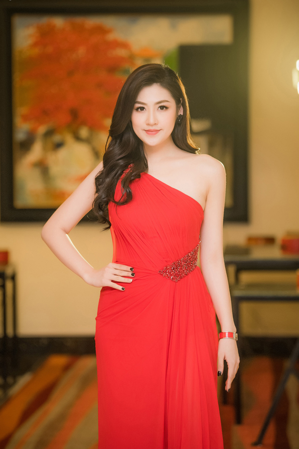 Á hậu Việt Nam 2012 chọn đầm lệch vai, đỏ rực rất nổi bật khi tham dự một sự kiện ở Hà Nội. Người đẹp hoàn thiện phong cách bằng mái tóc xoăn nhẹ và kiểu trang điểm nhẹ nhàng.